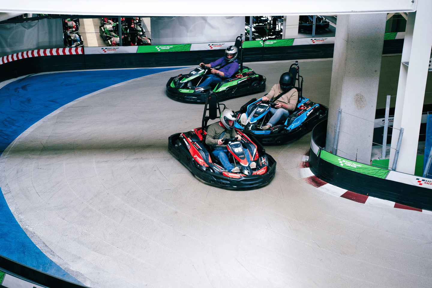 3 Karts fahren auf Raceway 3 um die Kurve und nehmen an einem Rennen teil. 