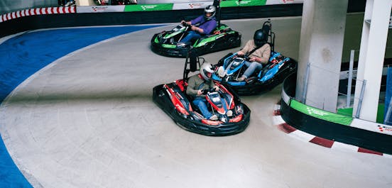 3 Karts fahren auf Raceway 3 um die Kurve und verteidigen Ihre Plätze im Rennen