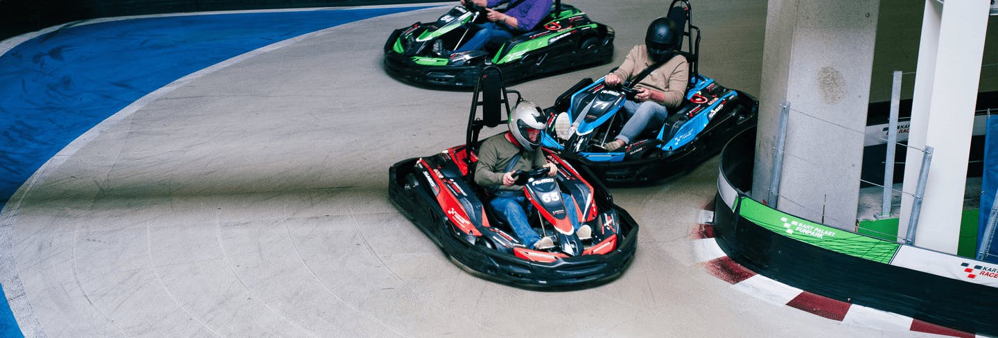 3 Karts fahren auf Raceway 3 um die Kurve und verteidigen Ihre Plätze im Rennen