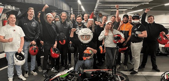 Eine Gruppe von Erwachsenen in der Boxengasse vor Beginn des Rennens