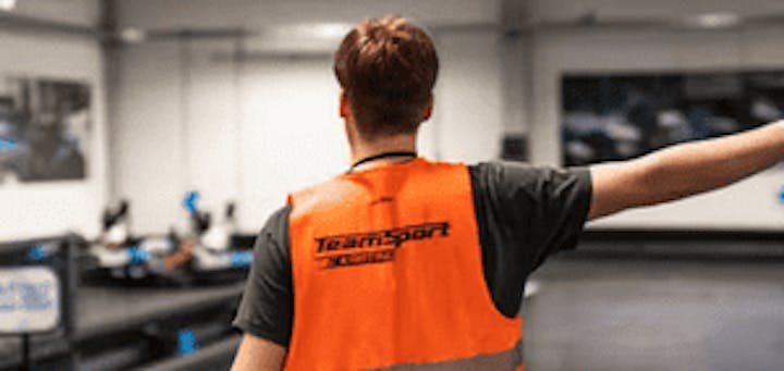 Member of TeamSport staff directing karts on track