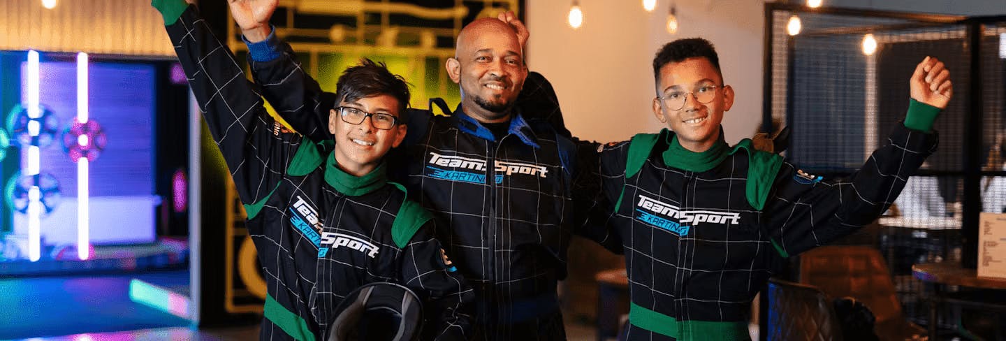 Father and two sons in karting gear 