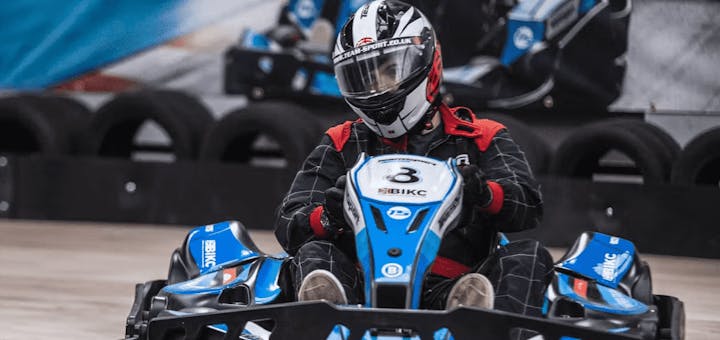 male karter in blue electric kart