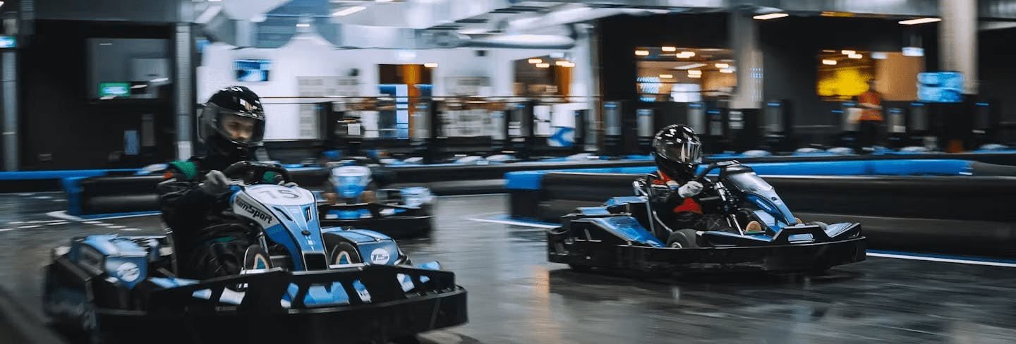 two karters racing in blue electric karts