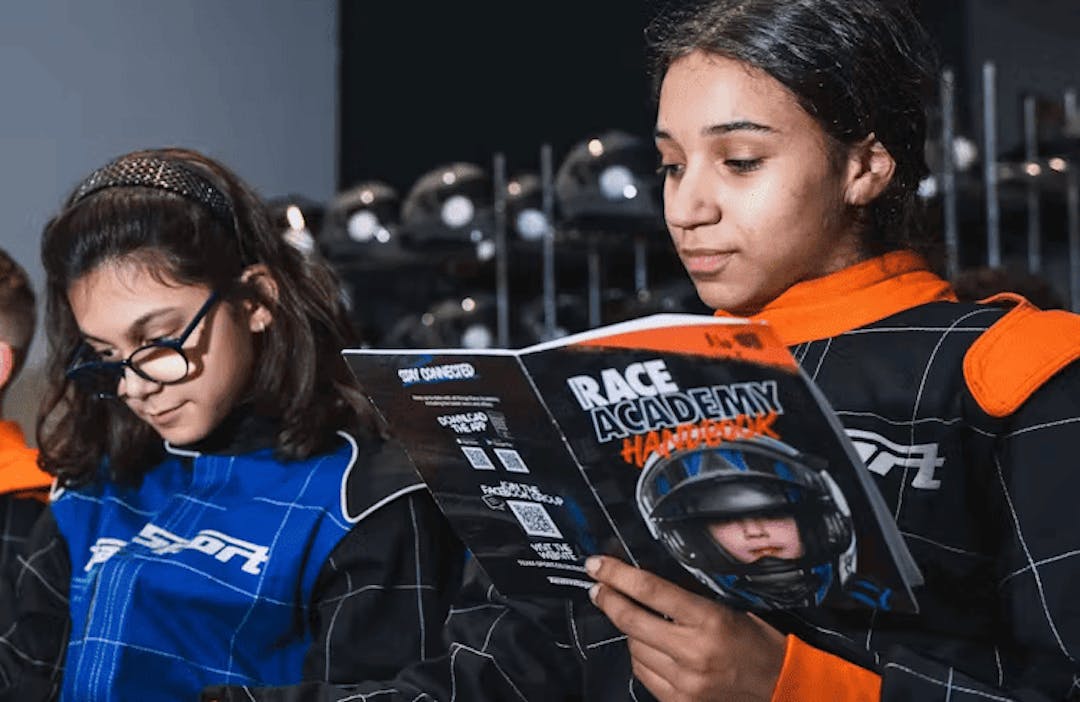 Race Academy lesson with children reading the handbook