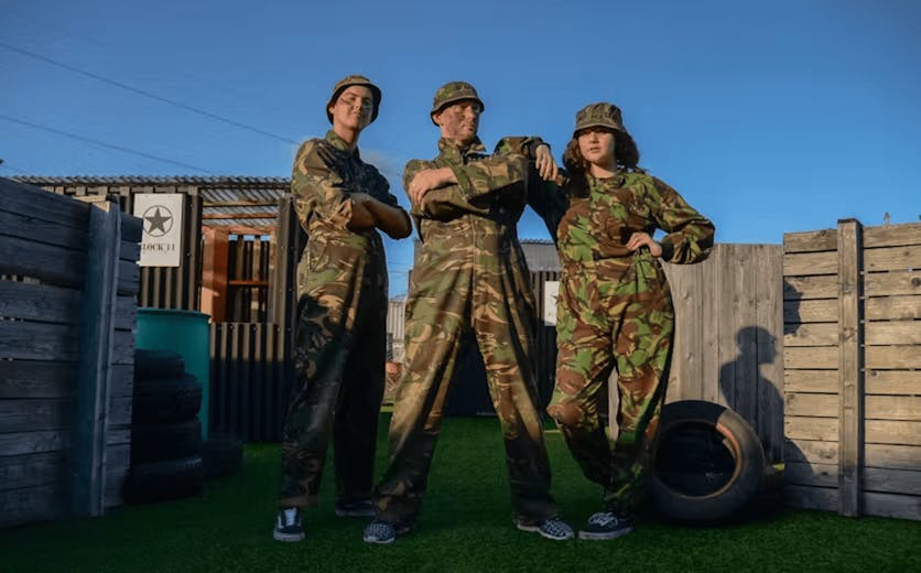 three people dressed in camouflage at laser combat venue