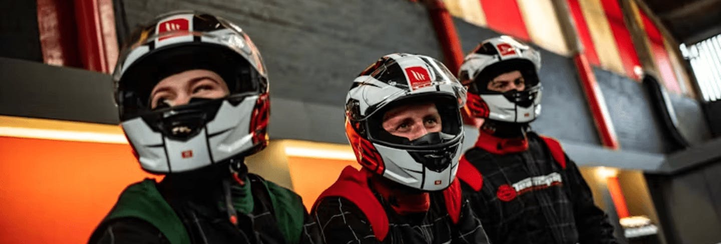 three karters watching others kart