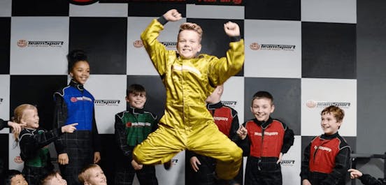 kids birthday party with children standing on podium (birthday boy in special gold suit)