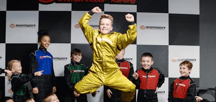 kids birthday party with children standing on podium (birthday boy in special gold suit)
