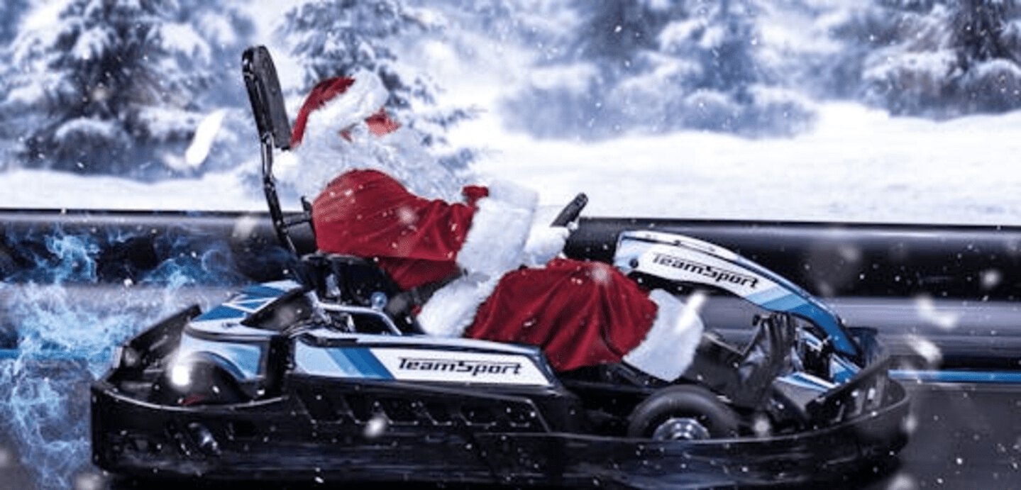 Der Weihnachtsmann sitzt in einem TeamSport Kart und fährt in weihnachtlicher Stimmung 