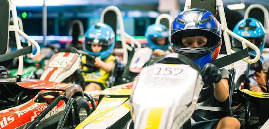 Kinder sitzen in den Karts in der Boxengasse und sind bereit für den Start