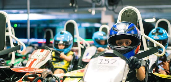 Kinder sitzen in den Karts in der Boxengasse und sind bereit für den Start