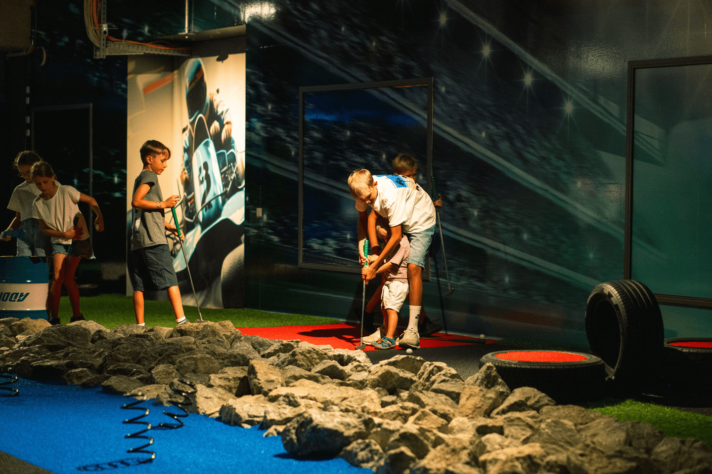 Eine Gruppe von Kindern spielt auf dem Adventure Minigolf Platz und hat Spaß