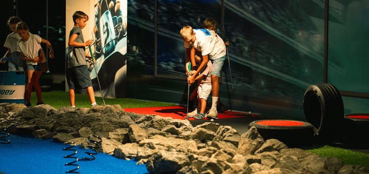 Eine Gruppe von Kindern spielt auf dem Adventure Minigolf Platz und hat Spaß