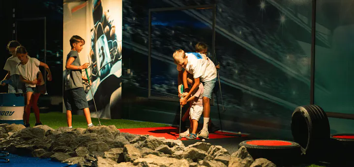 Eine Gruppe von Kindern spielt auf dem Adventure Minigolf Platz und hat Spaß