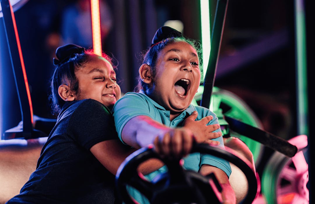 Two kids in putt club golf kart