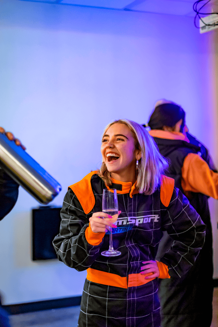 Girl in race suit smiling with bubbles 