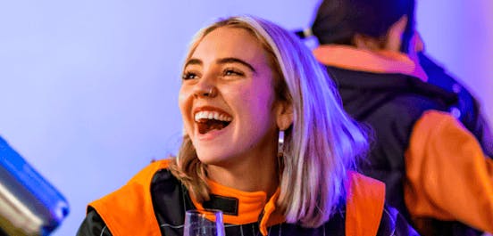 Girl in race suit smiling with bubbles