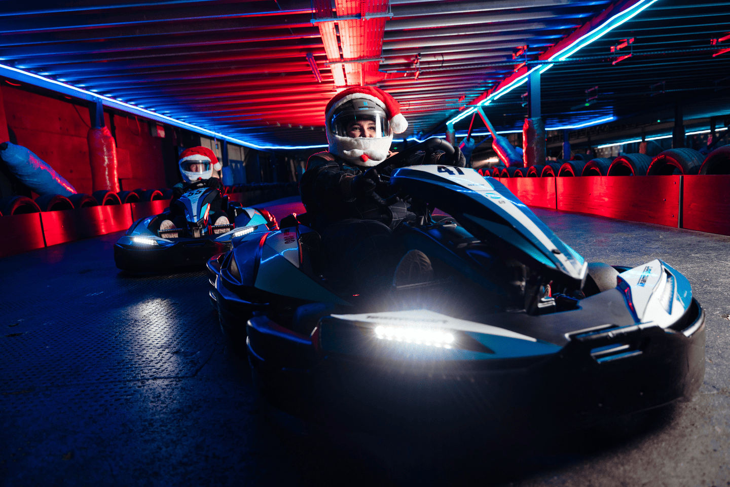 Two karters with festive santa hat helmets