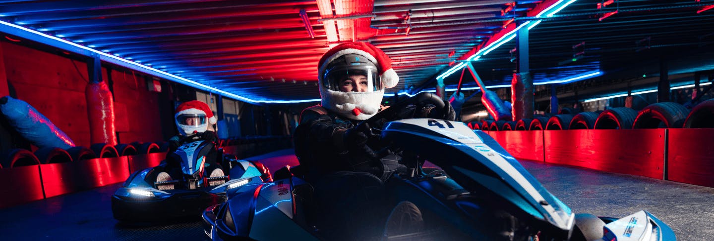 Two karters with festive santa hat helmets