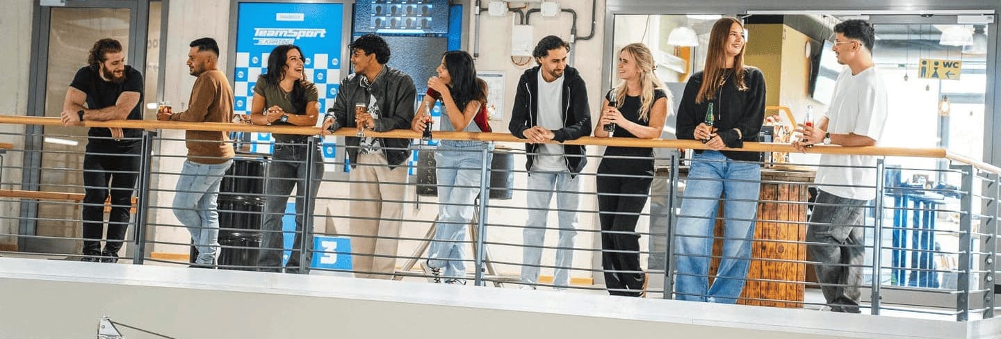 Eine Gruppe von Menschen steht auf der Aussichtsplattform und schaut dem Rennen zu.