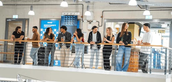 Eine Gruppe von Menschen steht auf der Aussichtsplattform und schaut dem Rennen zu.