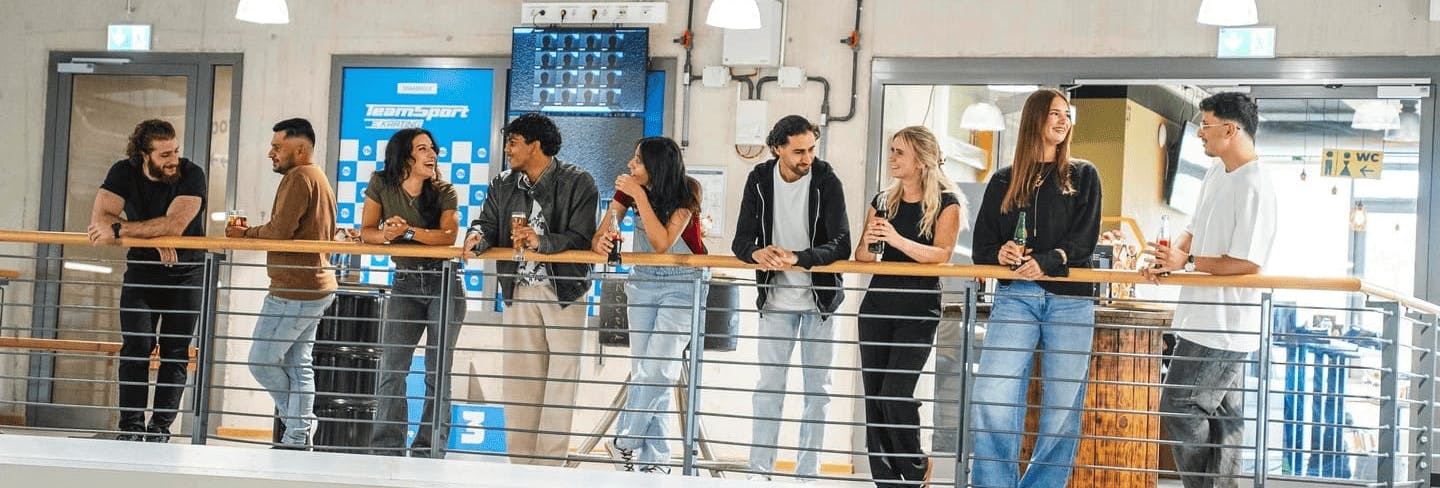 Eine Gruppe von Menschen steht auf der Aussichtsplattform und schaut dem Rennen zu.