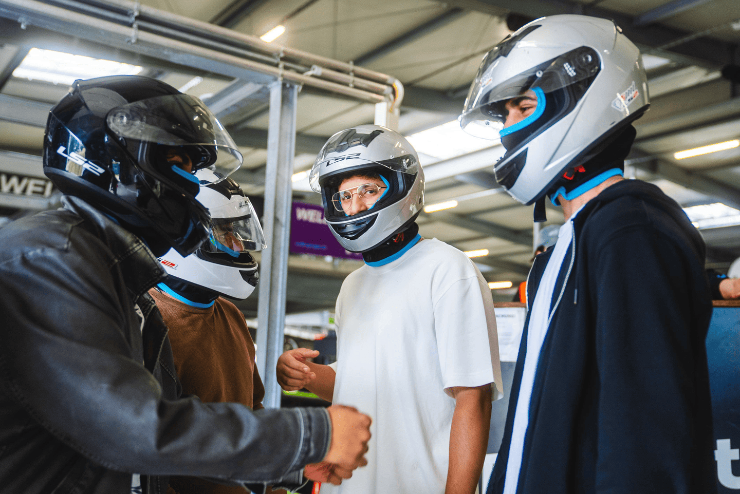 Männer mit Helmen vor dem Rennen in der Boxengasse