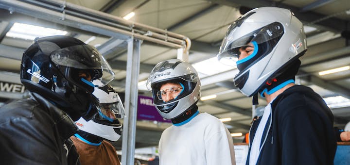 Männer mit Helmen vor dem Rennen in der Boxengasse