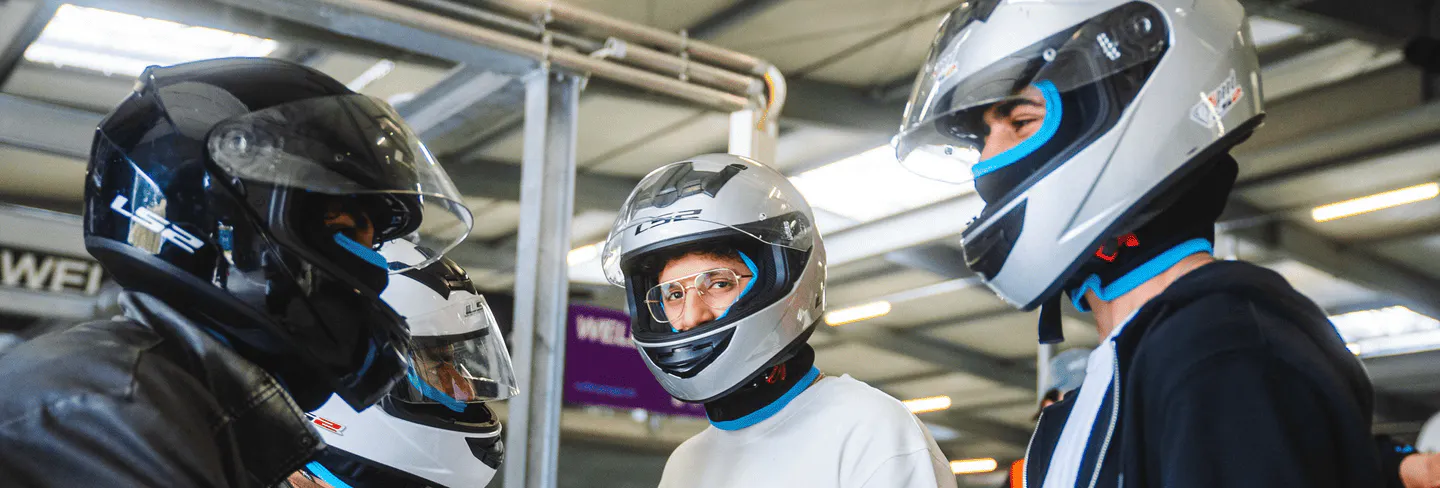 Männer mit Helmen vor dem Rennen in der Boxengasse