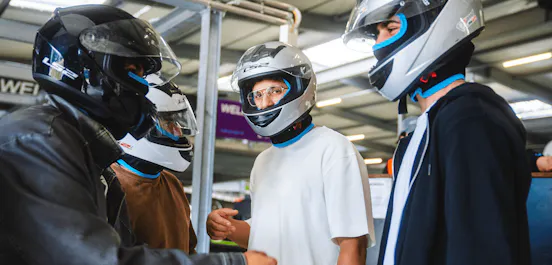 Männer mit Helmen vor dem Rennen in der Boxengasse
