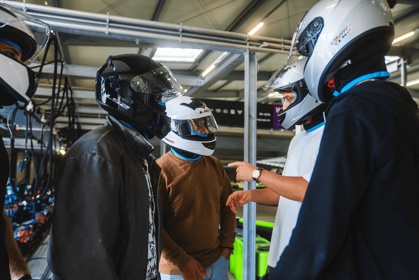 Männer mit Helmen vor dem Rennen in der Boxengasse
