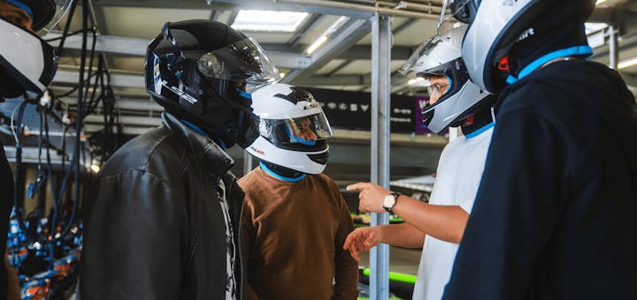 Männer mit Helmen vor dem Rennen in der Boxengasse