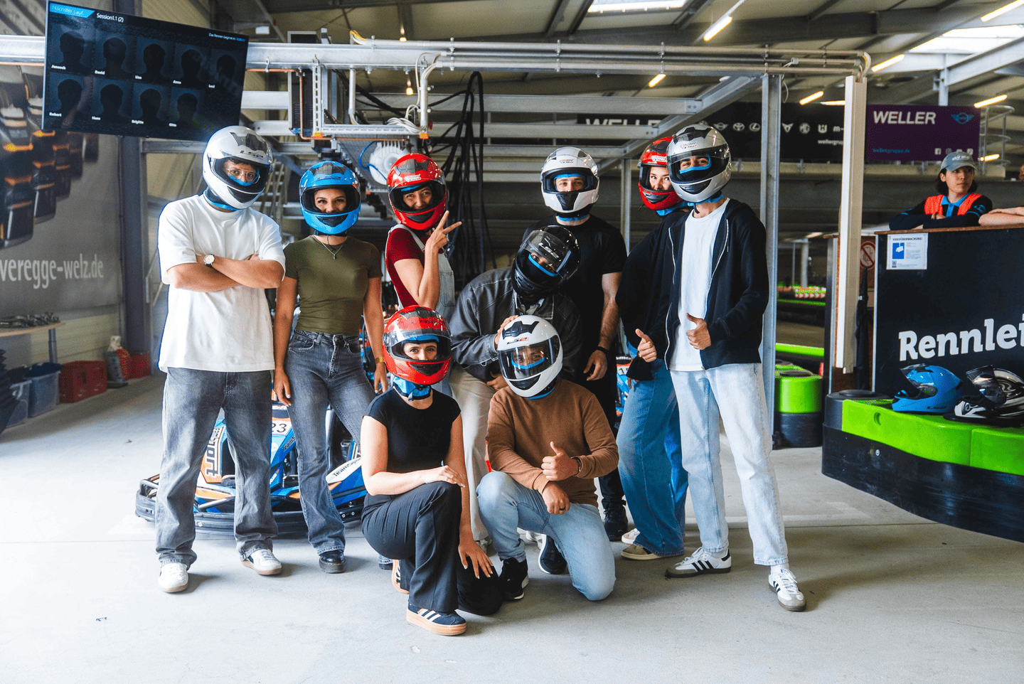 Eine große Gruppe von Teilnehmern mit Helmen vor dem Rennen in der Boxengasse