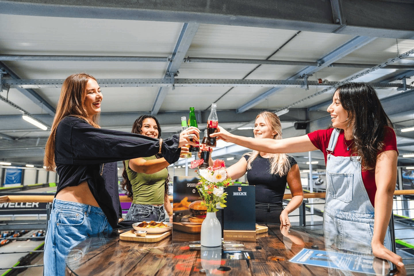Eine Gruppe von Frauen steht auf der Aussichtsplattform an einem Tisch und stößt an. 