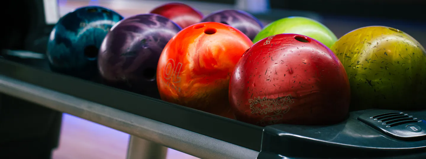 Close up of bowling balls lined up on ball return