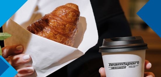 Eine Frau hält ein Croissant und ein Kaffee-to-go-Becher