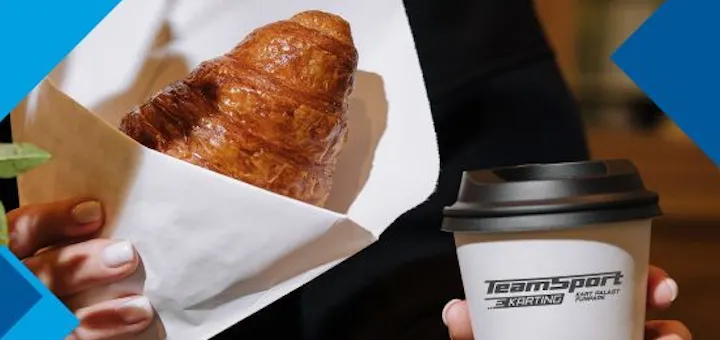 Eine Frau hält ein Croissant und ein Kaffee-to-go-Becher