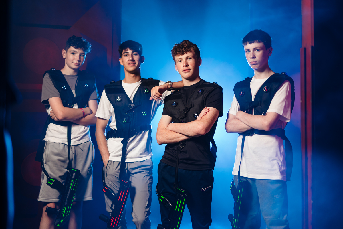 Group of players posing with laser tag gear in a neon‑lit arena.