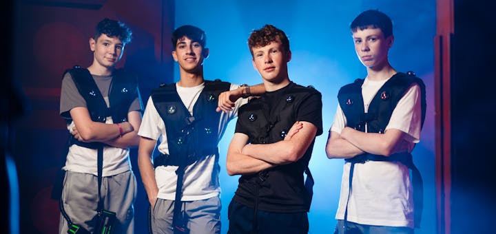 Group of players posing with laser tag gear in a neon‑lit arena.