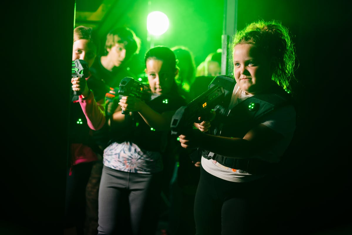 Players battling in a dark, UV‑lit laser tag arena in Bristol