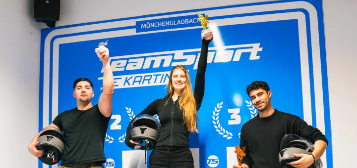 Drei Personen stehen auf Siegerpodest