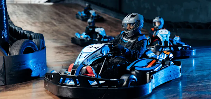 Group of go karters in blue electric karts