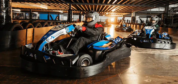 Group of go karters in blue electric karts