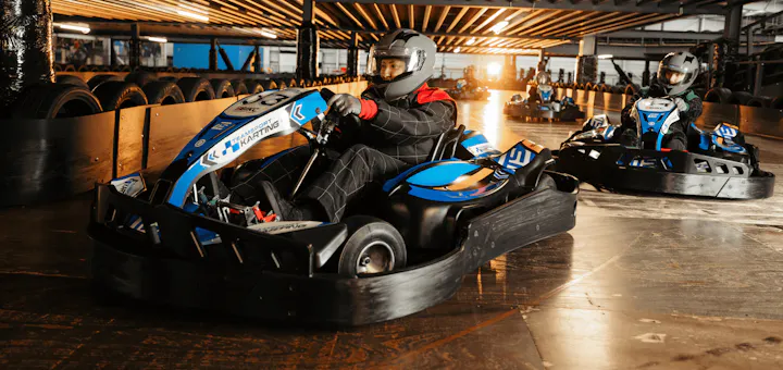 Group of go karters in blue electric karts