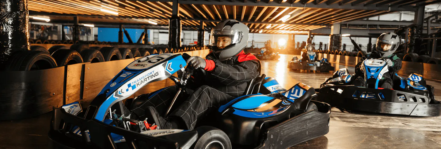 Group of go karters in blue electric karts
