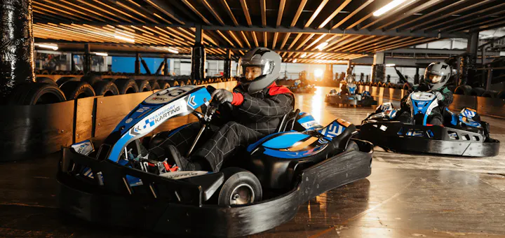 Group of go karters in blue electric karts