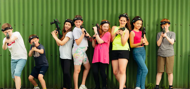 Large group playing laser tag in a busy indoor arena