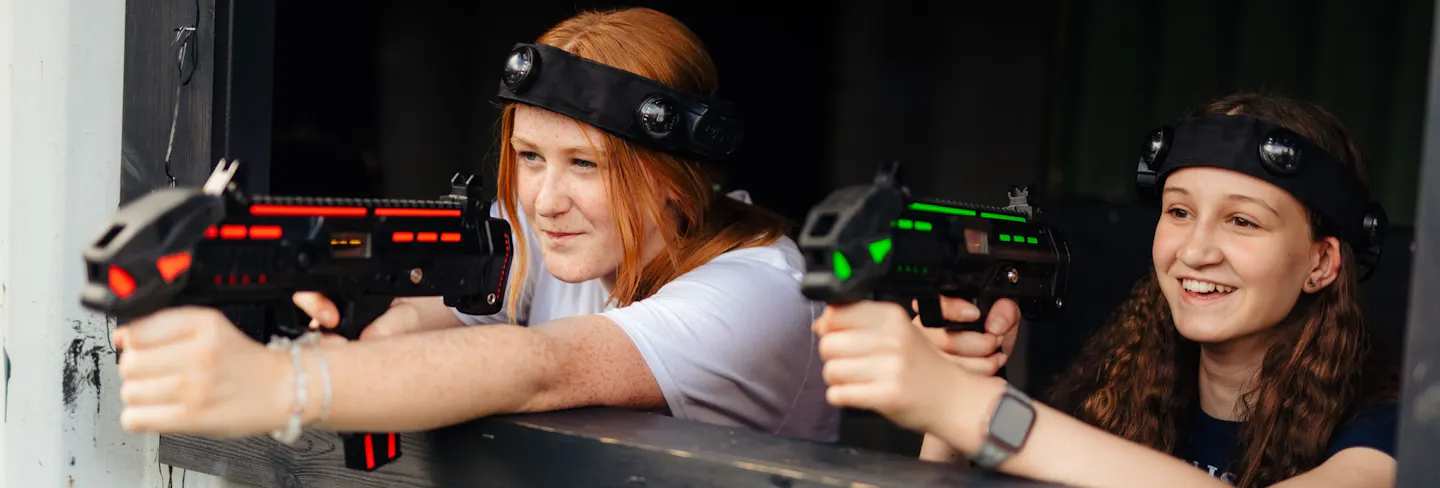 Players aiming laser tag blasters during a fast‑paced game
