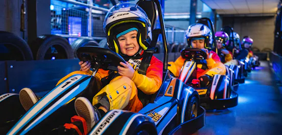 Child enjoying their first go karting experience in a mini racer